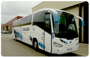 Autobús blanco estacionado junto a un edificio en una zona industrial.