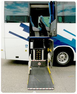 Puerta de autobús abierta con elevador para sillas de ruedas extendido hasta la acera en un autobús blanco