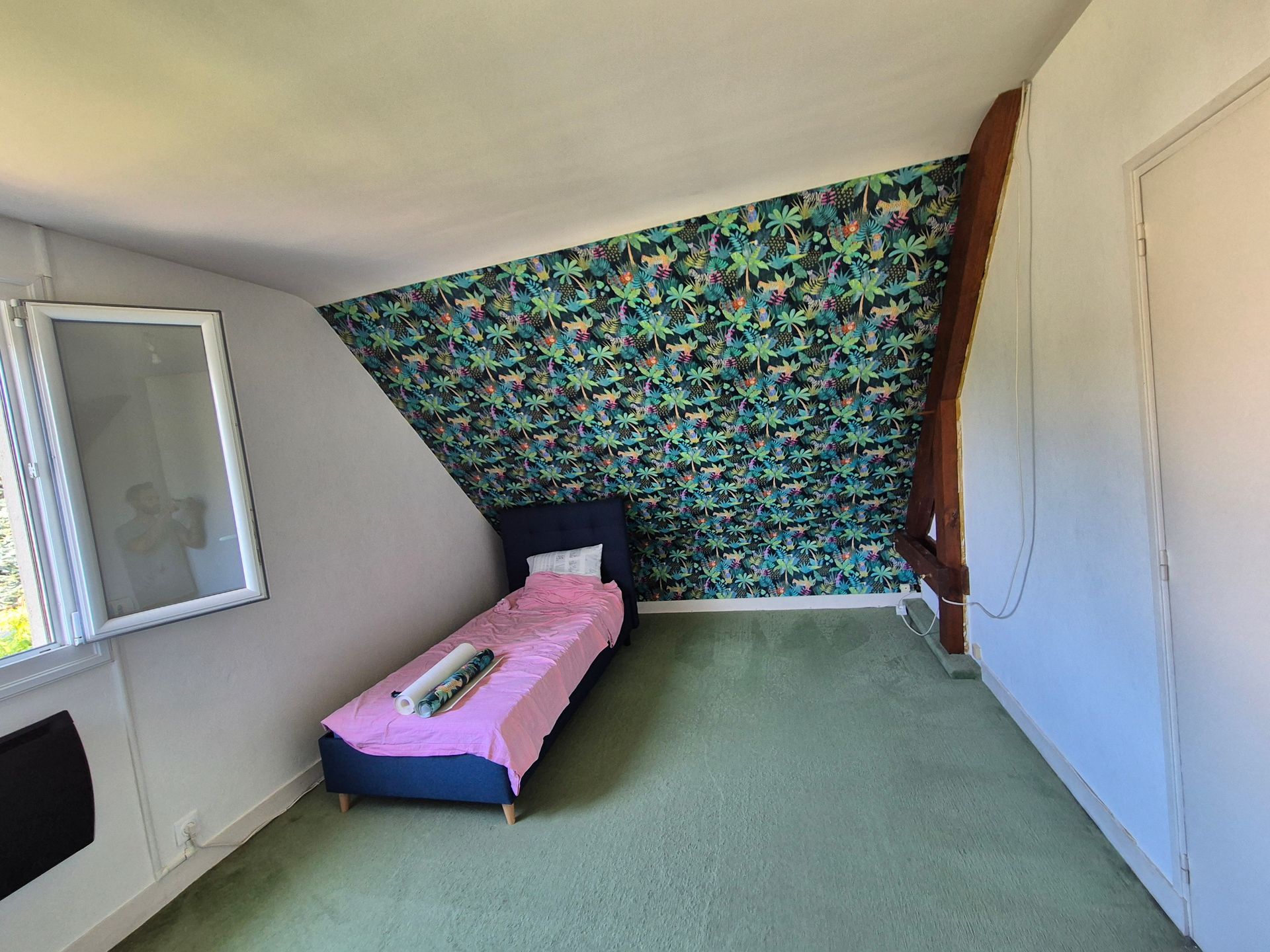 Chambre avec un pan entier couvert de papier peint à motifs