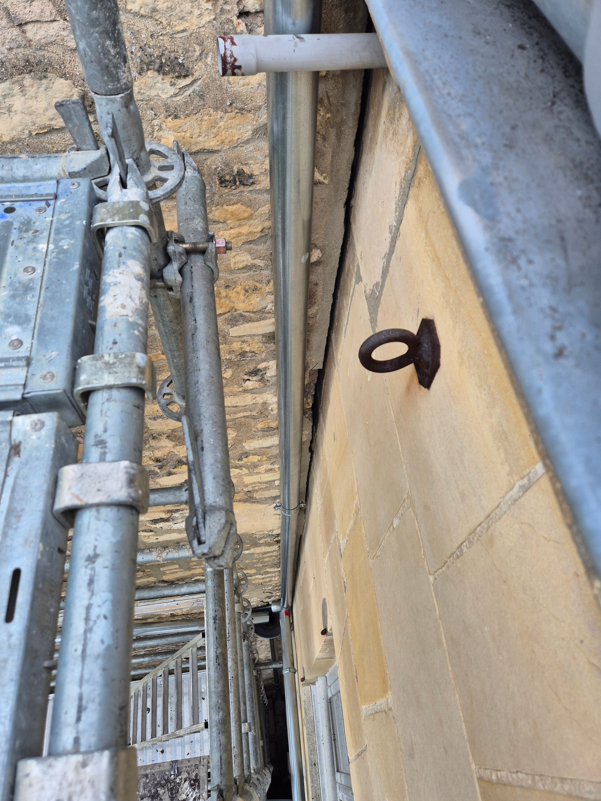 Échafaudage et mur en pierre à nettoyer et réparer