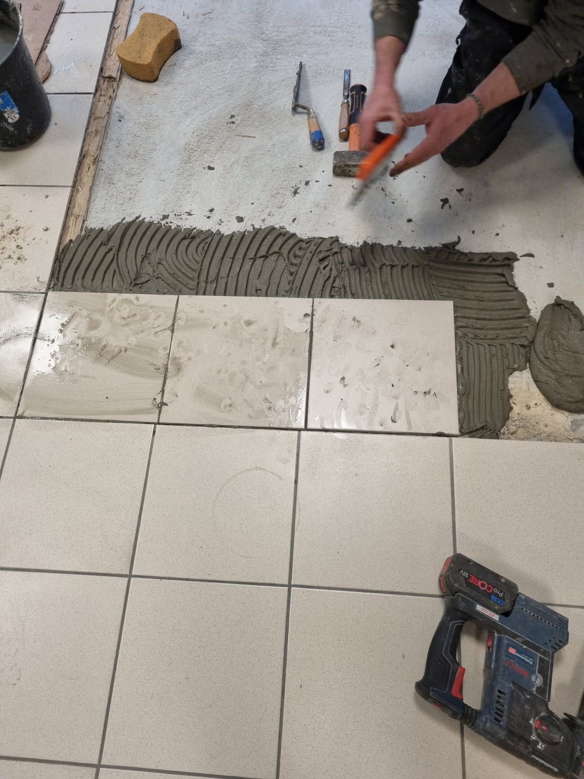 Pose en cours de carrelage avec des carreaux de forme carrée