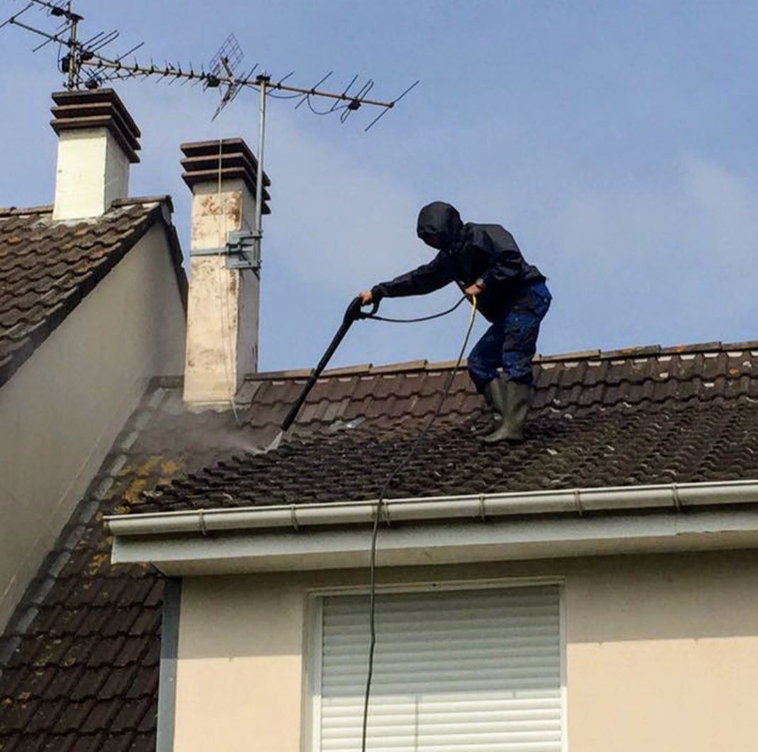 Nettoyage de toiture en cours avec un jet à basse pression