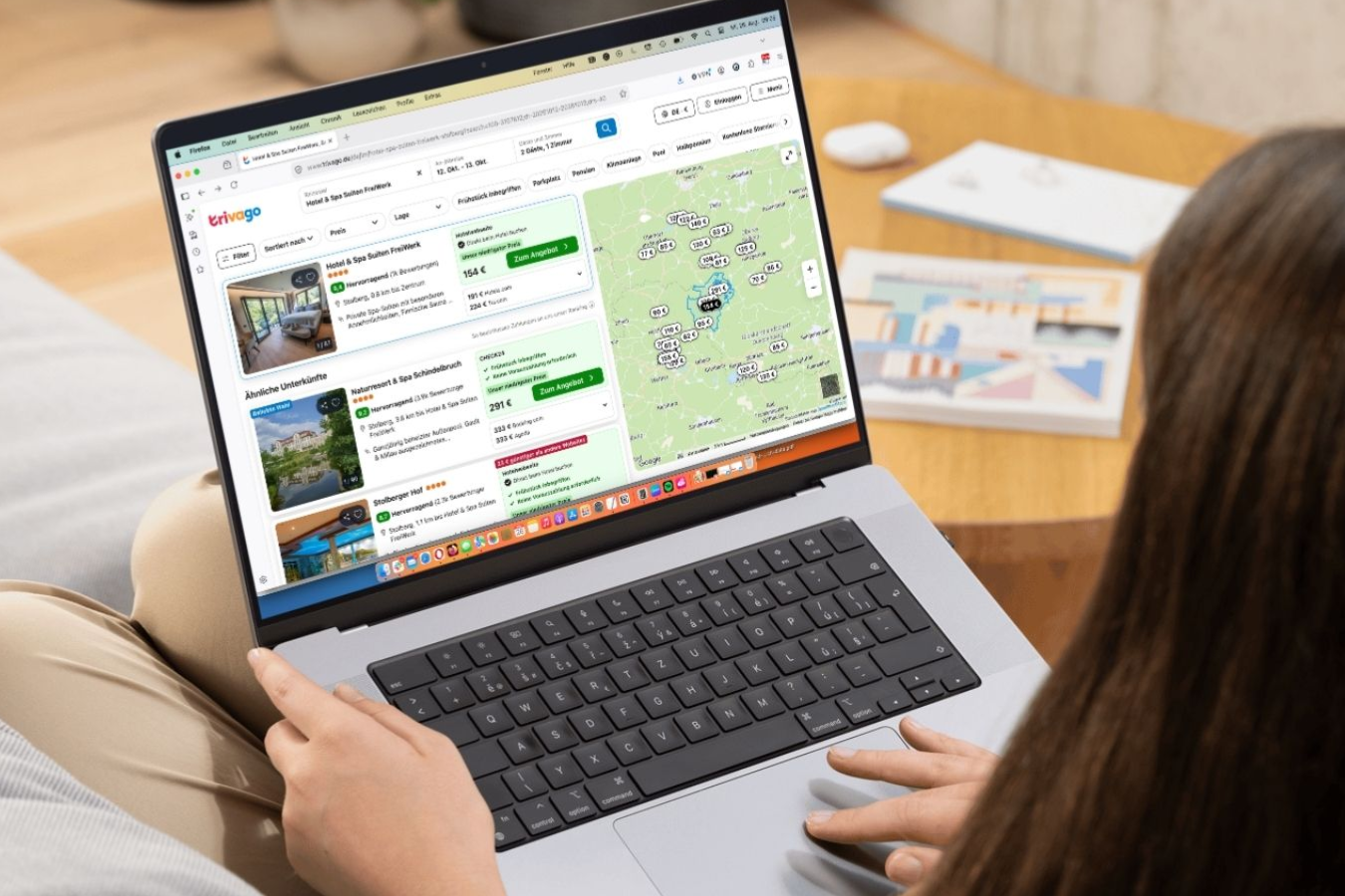 Eine Person sitzt auf einem Sofa und benutzt einen Laptop