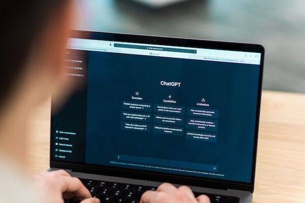 Person tippt auf einem Laptop mit dunklem Dashboard-Bildschirm