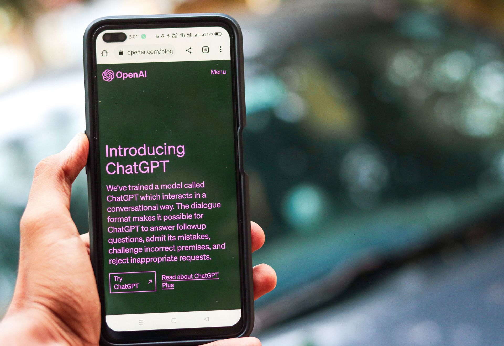 Eine Hand hält ein Smartphone, auf dessen dunklem Bildschirm die ChatGPT