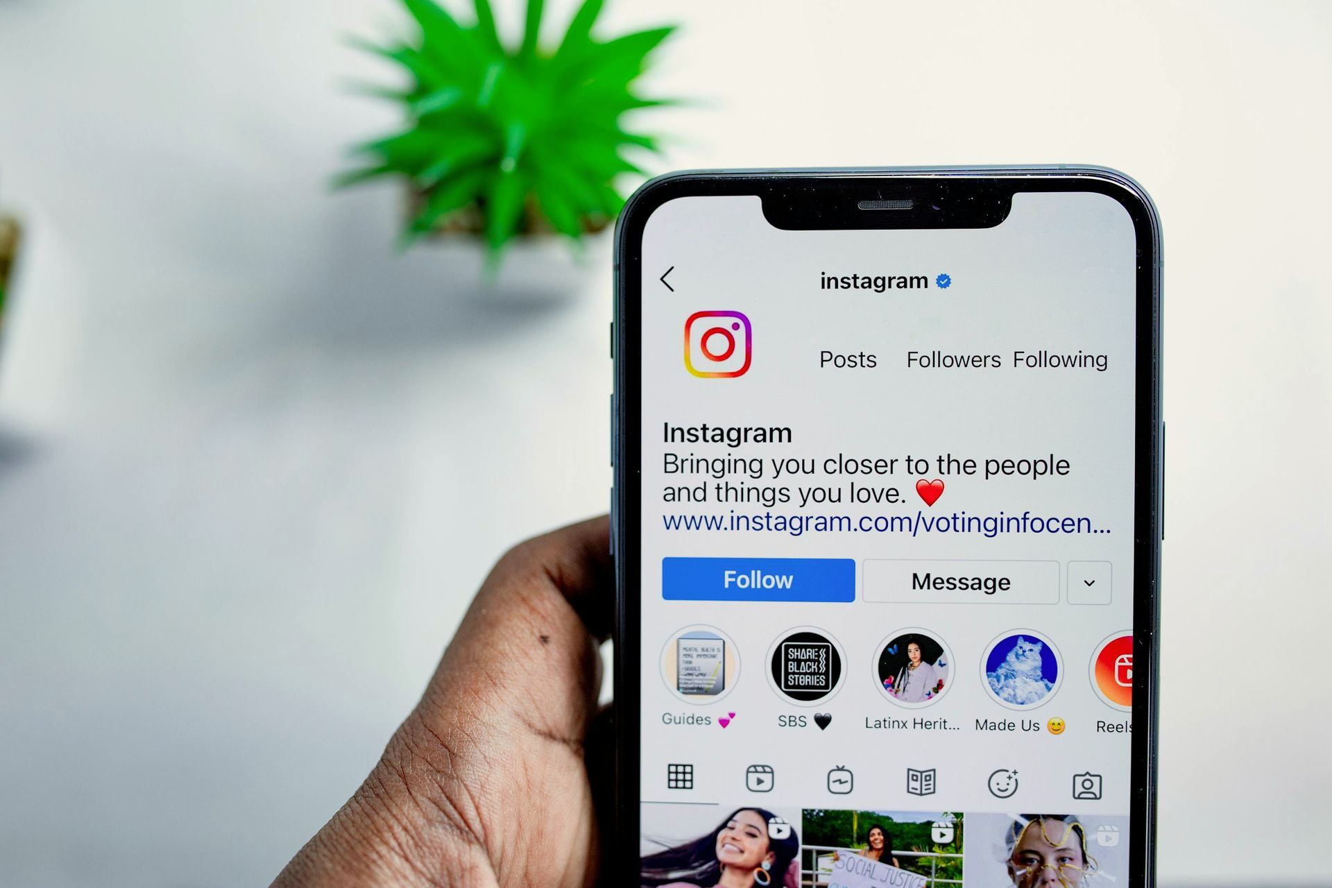 Eine Hand hält ein Smartphone, auf dem ein Instagram-Profil angezeigt
