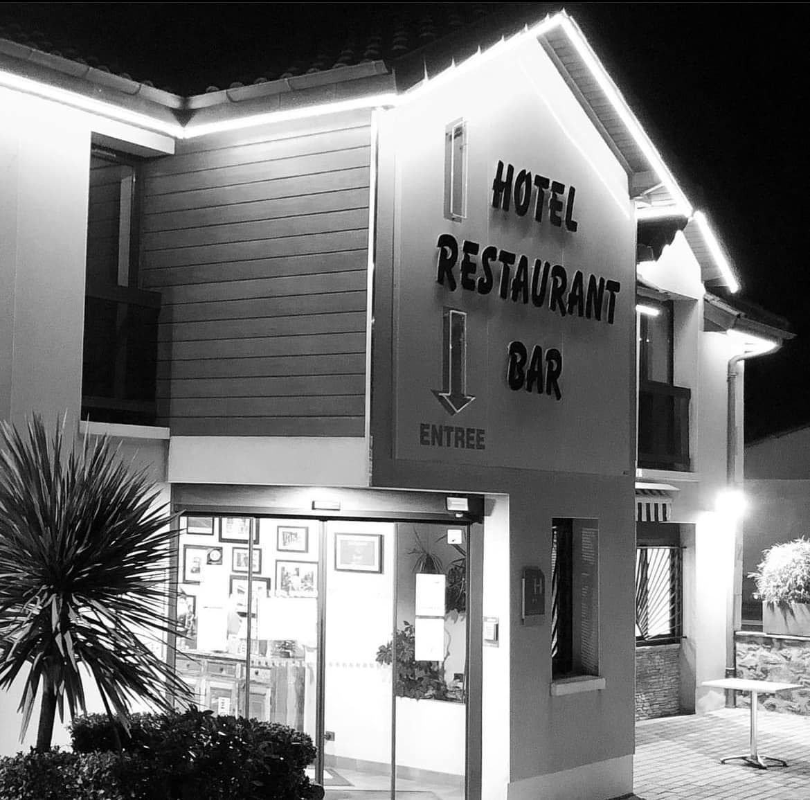 Bâtiment d'hôtel avec enseigne illuminée la nuit.