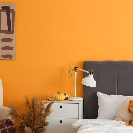 Une chambre avec un mur orange