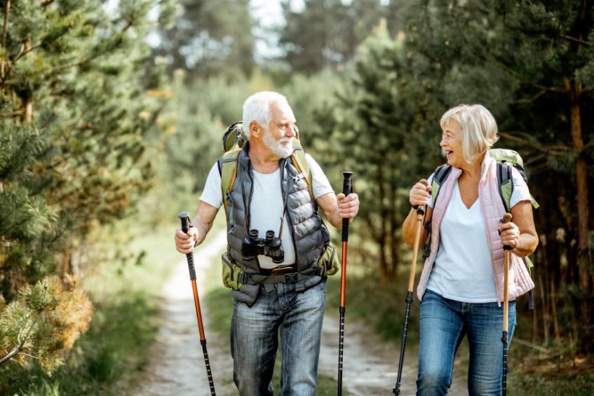 Un hombre y una mujer están caminando por el bosque.