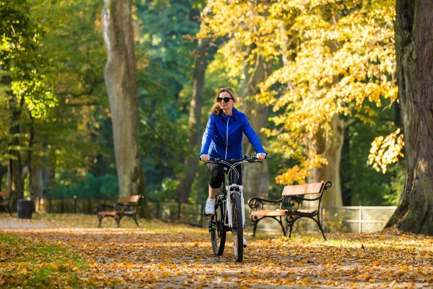Una mujer va en bicicleta en un parque.