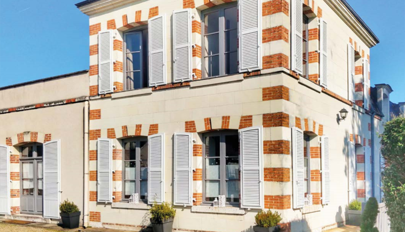 Maison à étage avec volets blancs