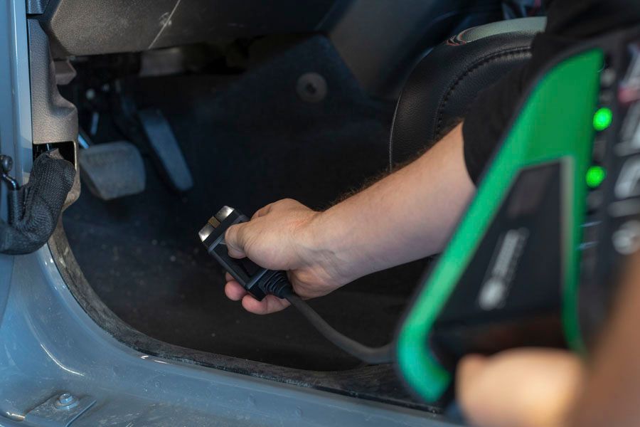 Eine Person benutzt eine Fernbedienung, um eine Autotür aufzuschließen.