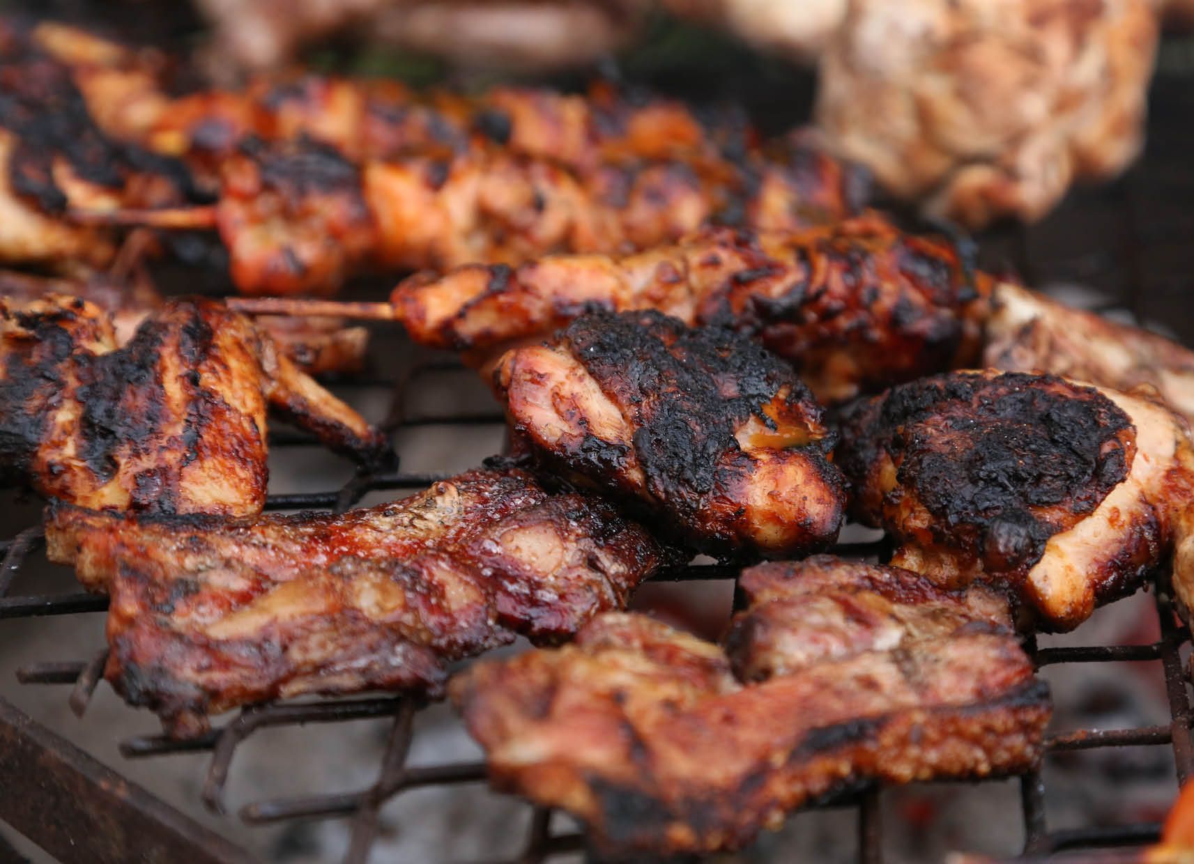 A bunch of meat is cooking on a grill.