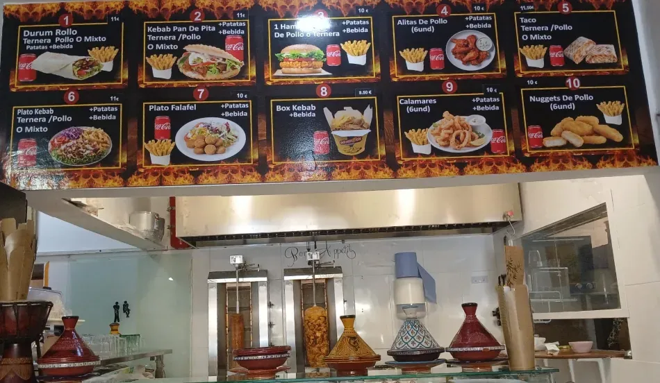 Restaurant counter with a menu board showing food photos and dishes on display below