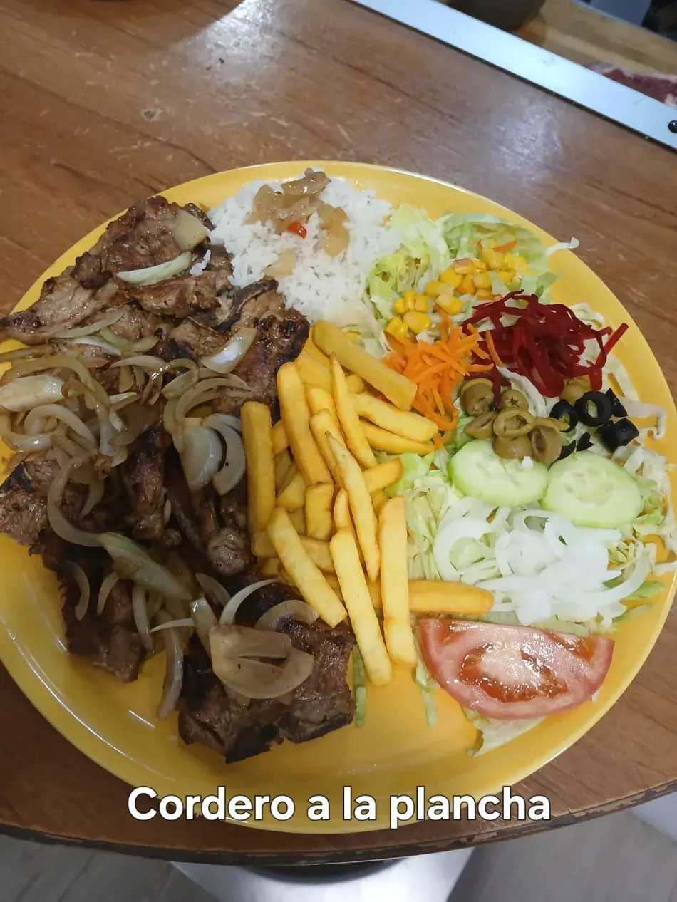 Plato de cordero a la plancha con papas fritas, arroz, ensalada y vegetales