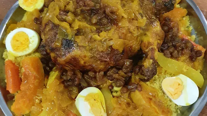 طبق من الأرز الأصفر مع اللحم، وشرائح البيض المسلوق، والجزر، يعلوه البصل المقلي.