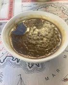 كوب من مشروب داكن على خريطة، كما تُرى من الأعلى.