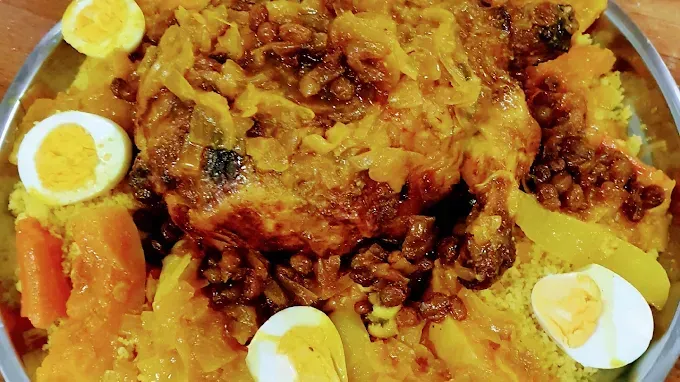 Arroz amarillo con carne asada, huevos duros partidos por la mitad y verduras en un plato.