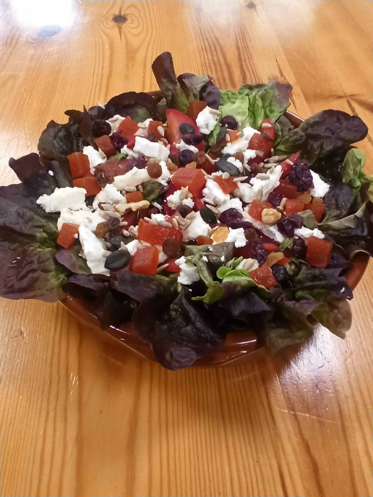Una ensalada en un bol sobre una mesa de madera
