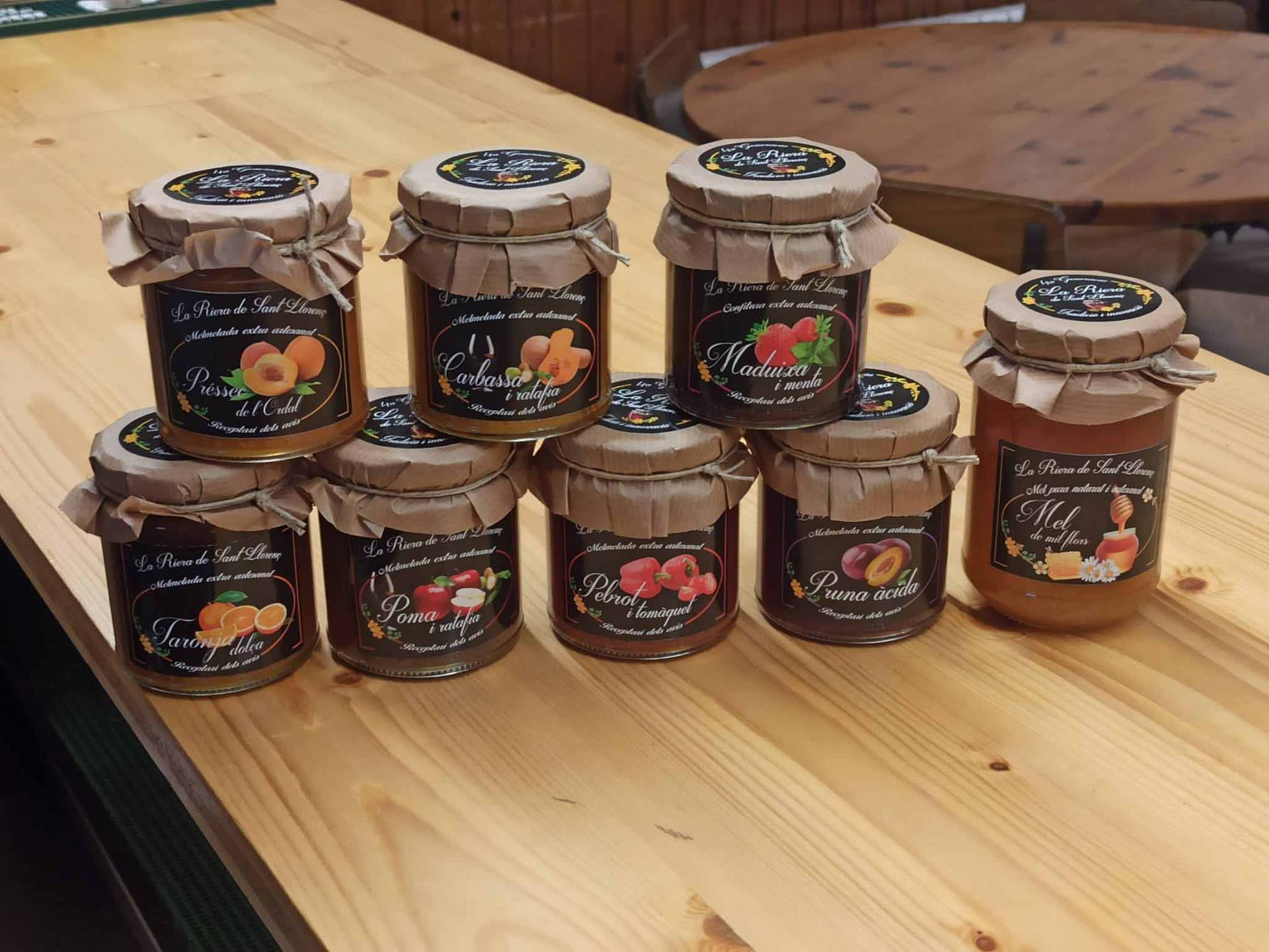 Varios frascos de mermelada están apilados uno encima del otro sobre una mesa de madera.