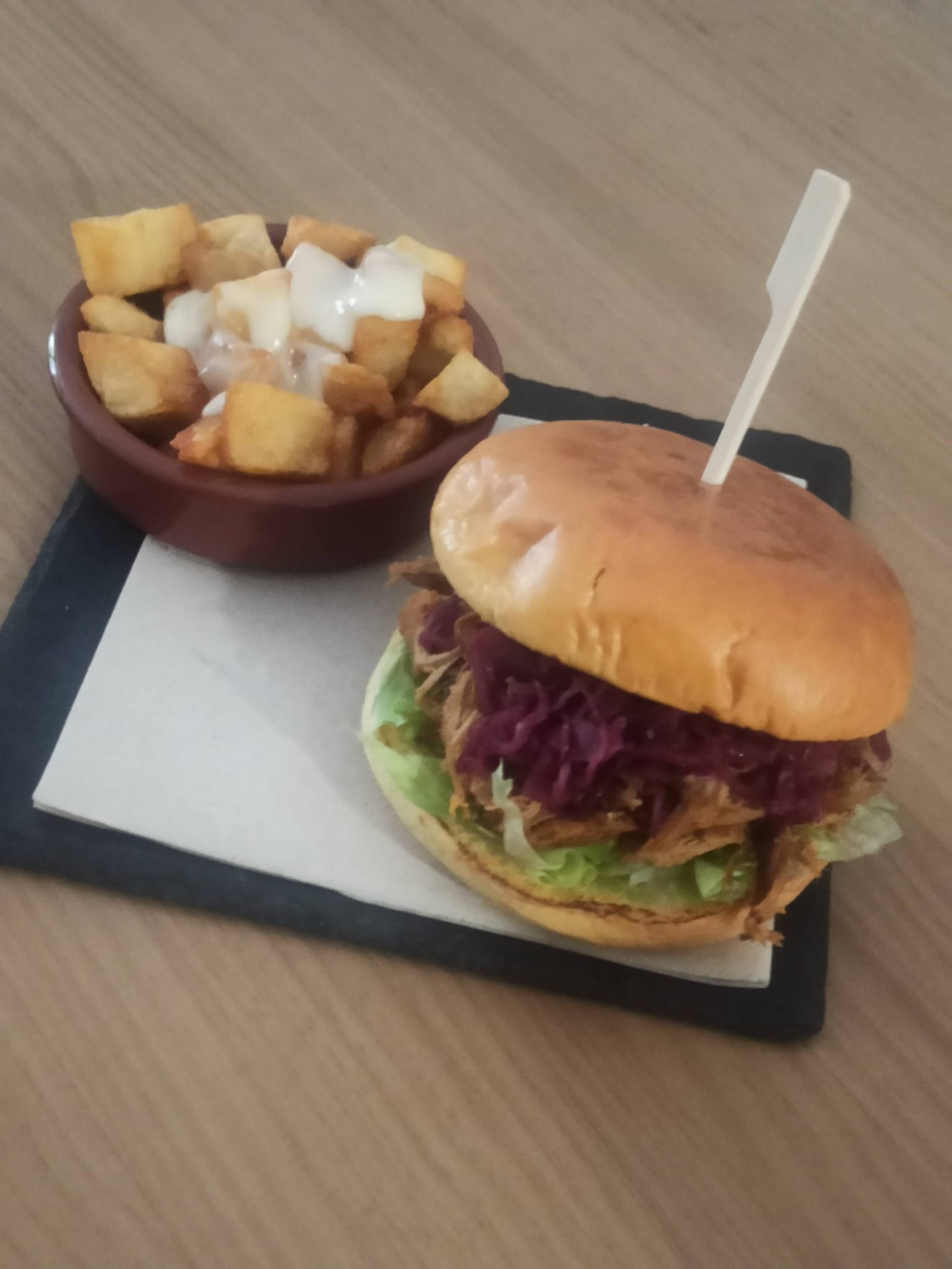 Una hamburguesa y un tazón de patatas en una servilleta