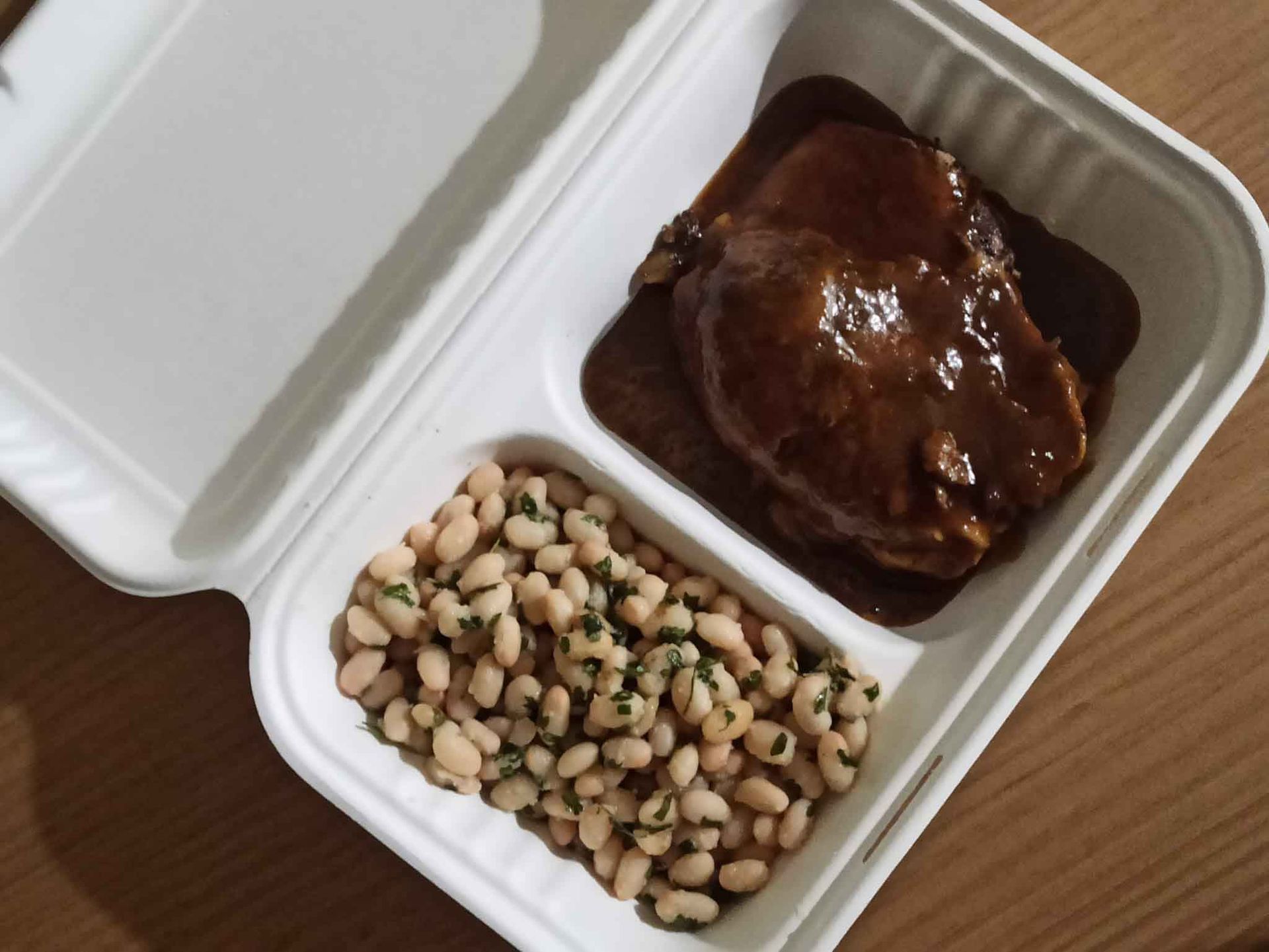 Un recipiente de poliestireno lleno de carne y frijoles