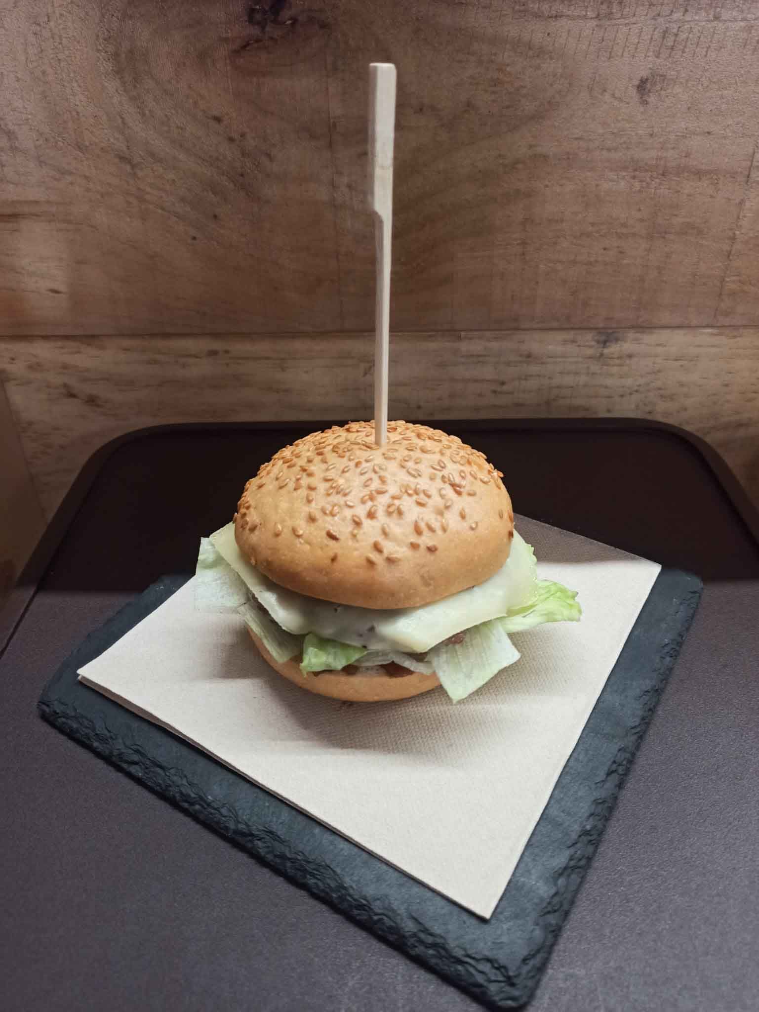 Una hamburguesa con lechuga y queso en un palillo.