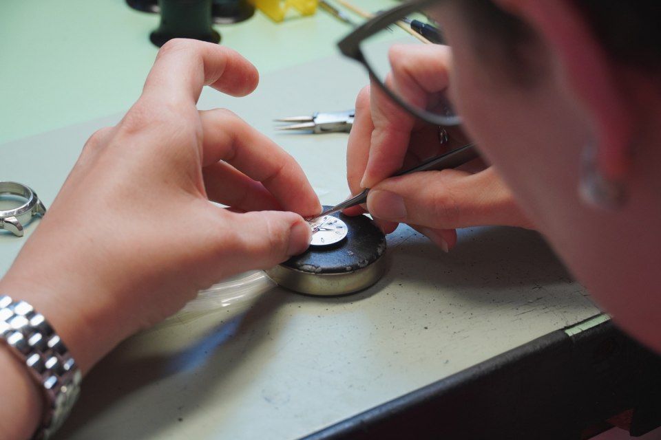 Eine Person mit Brille arbeitet an einer Uhr, Imfeld Uhren + Schmuck GmbH