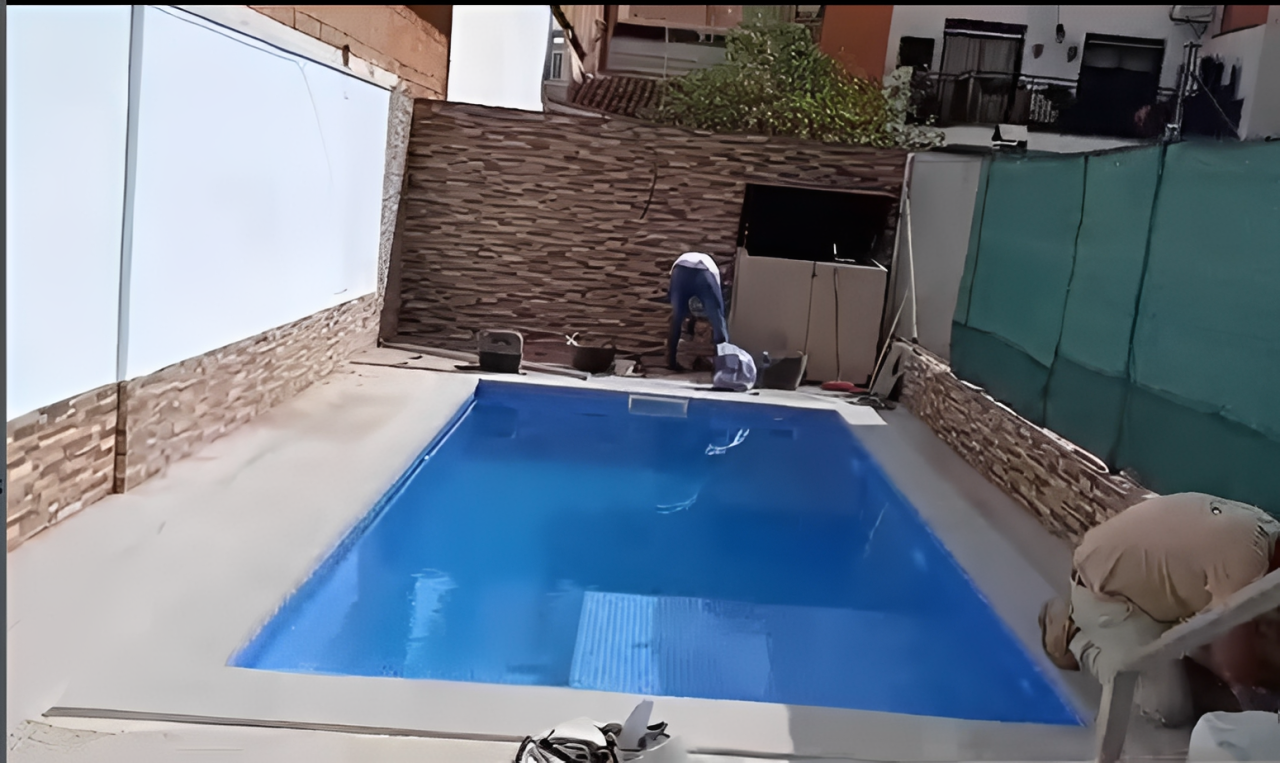 Los obreros de la construcción colocan los azulejos perimetrales