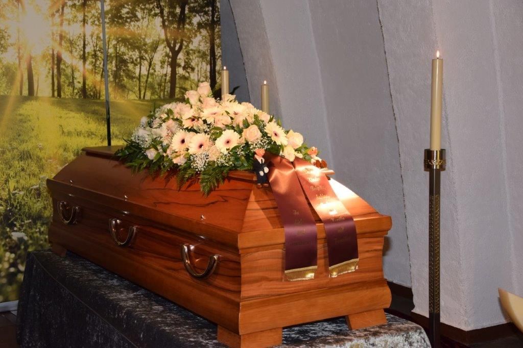 Ein Holzsarg mit Blumen darauf