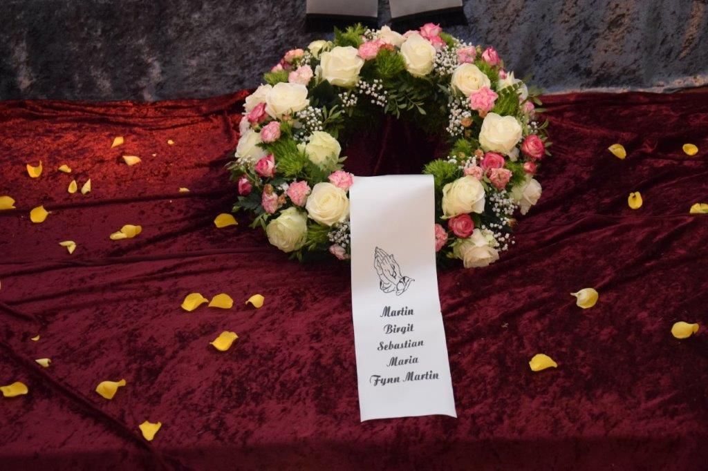 Ein Blumenkranz mit Blütenblättern steht auf einem Tisch