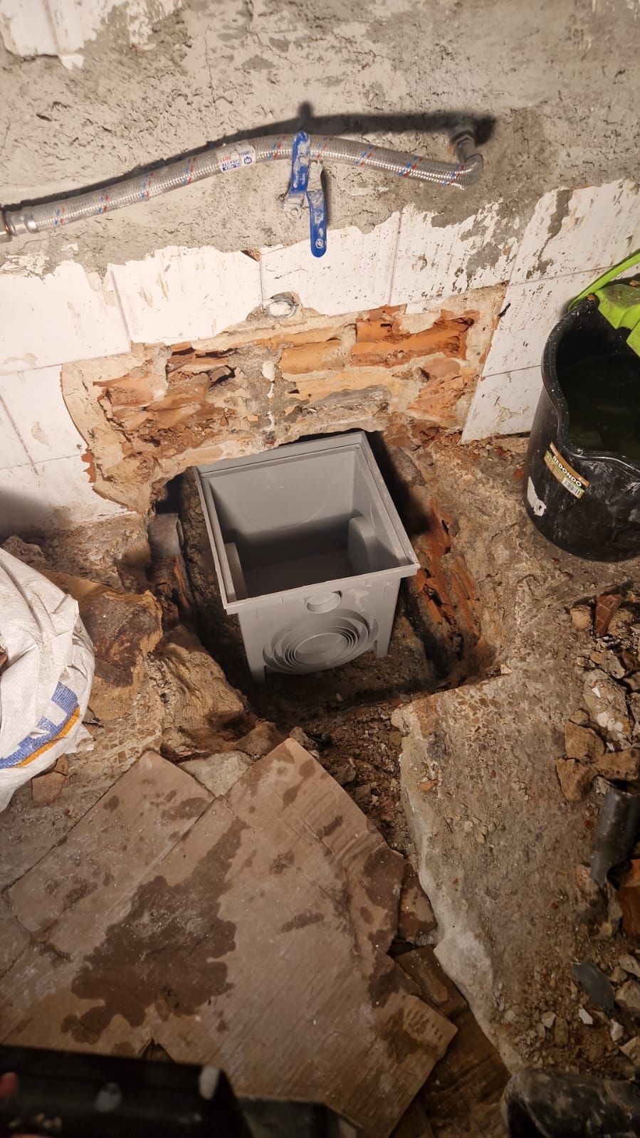 Se está instalando un desagüe en un agujero en una pared de ladrillos.