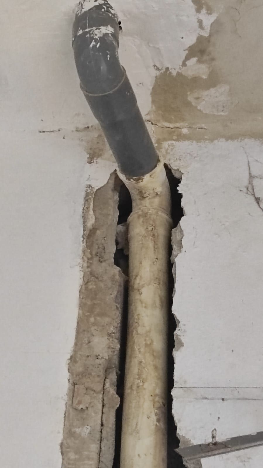 Una tubería sale de un agujero en la pared.