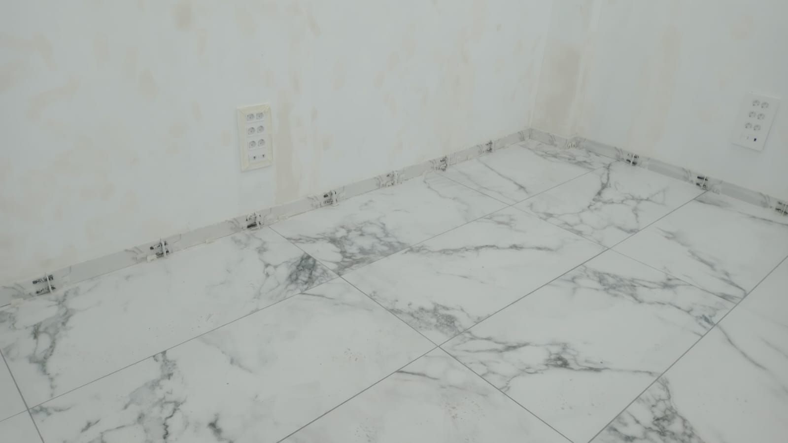 Hay un piso de mármol en la esquina de la habitación.