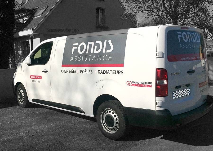 Fourgon d’intervention Fondis Assistance blanc stationné dans une rue, avec le logo de l’entreprise en rouge et gris.