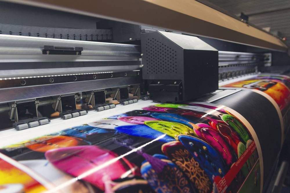 Imprimante grand format produisant une bannière vive et colorée dans un atelier d’impression industrielle