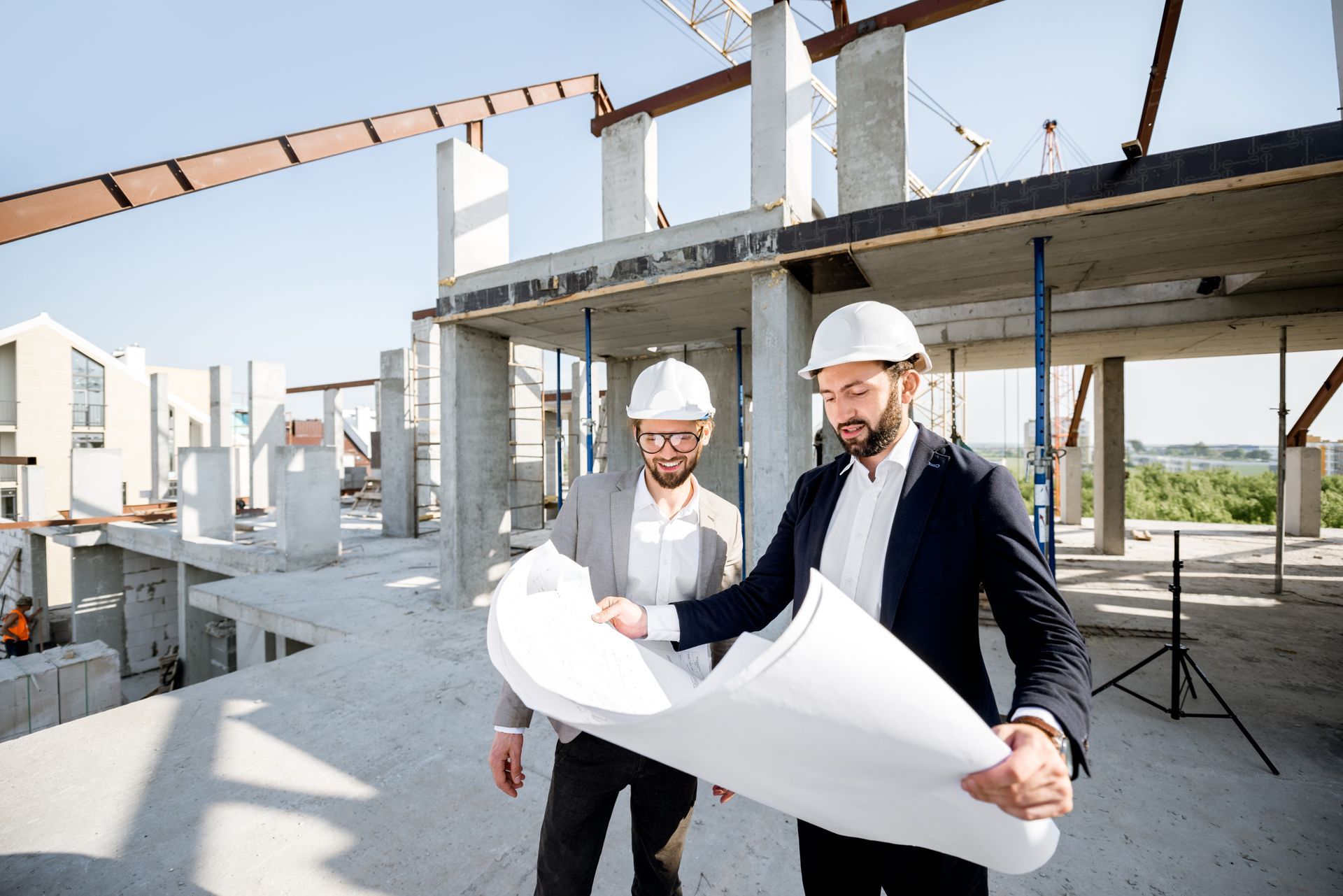 Deux ingénieurs examinent des plans sur un chantier de construction.