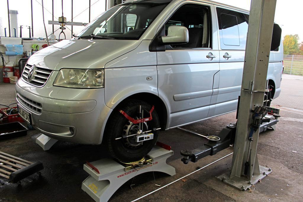 Ein silberner Lieferwagen steht auf einem Aufzug in einer Garage.