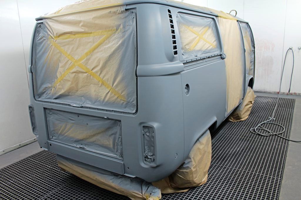 Ein Transporter wird in einer Lackierkabine lackiert.