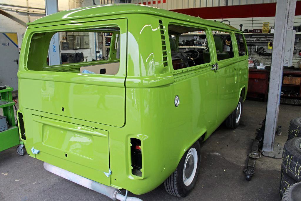Ein grüner Lieferwagen steht in einer Garage.