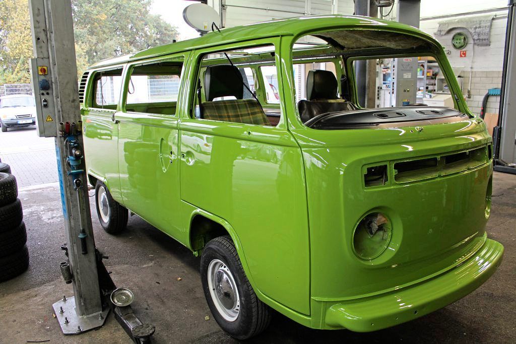 Ein grüner Lieferwagen steht in einer Garage.
