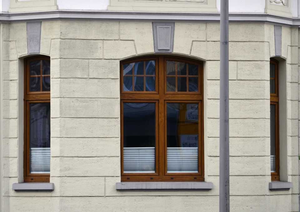 Altbauhaus mit braunen Fenstern und Querstegen