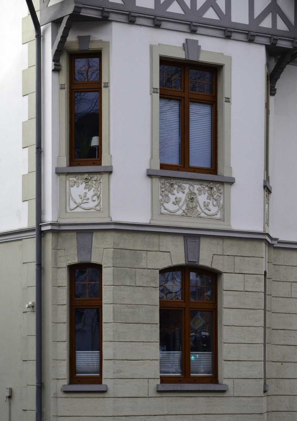 Altbauhaus mit Dekorationen und braunen Fenstern