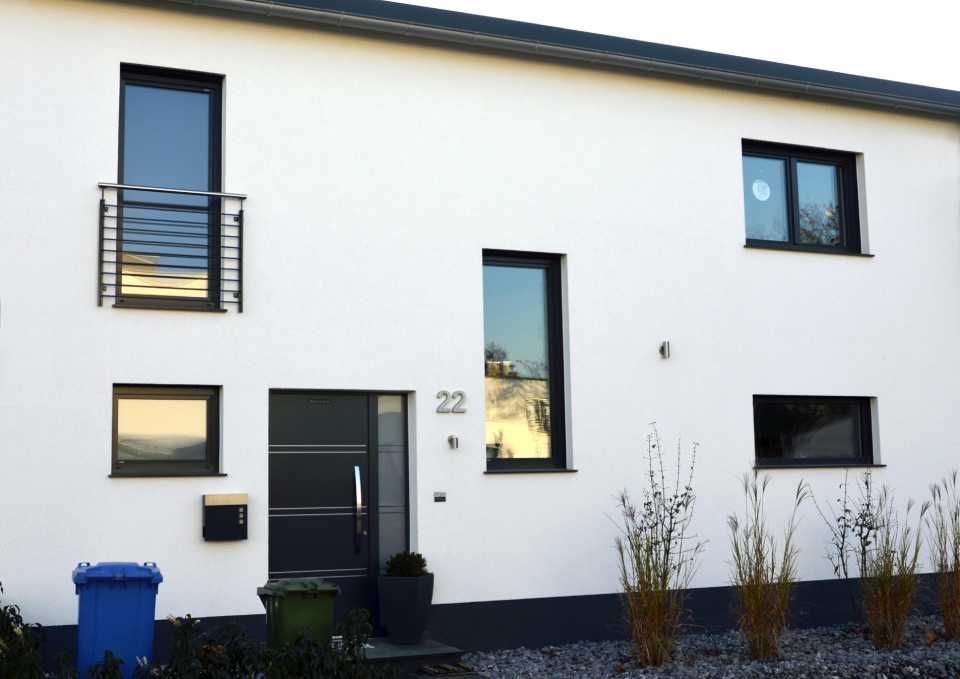 weißes Haus mit schwarzen Fenstern