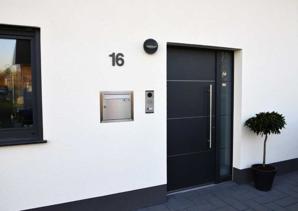 weißes Haus mit schwarzer Eingangstür