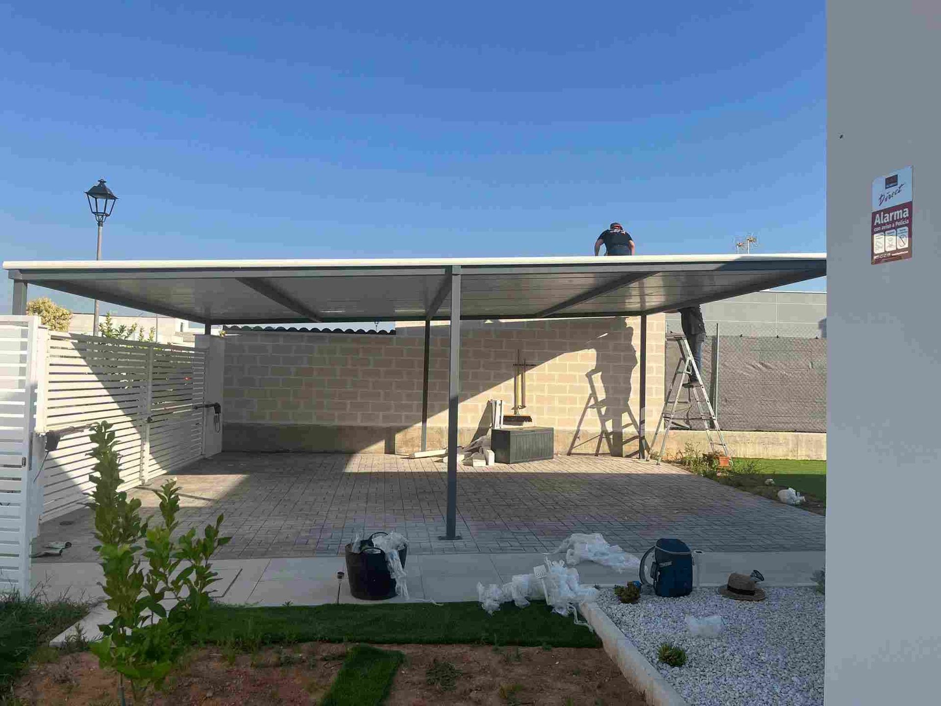 Persona con traje de protección rociando un sistema de pesticida montado en un vehículo sobre arbustos