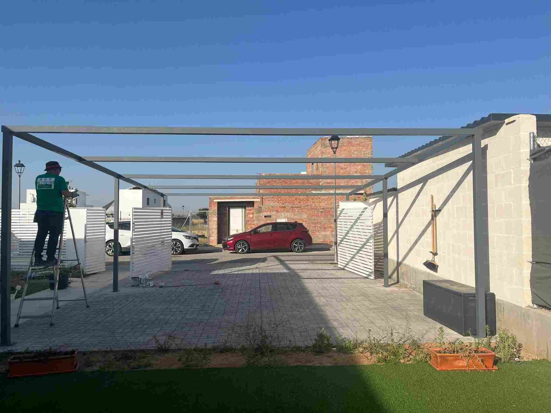 Persona con traje de protección rociando un sistema de pesticida montado en un vehículo sobre arbustos