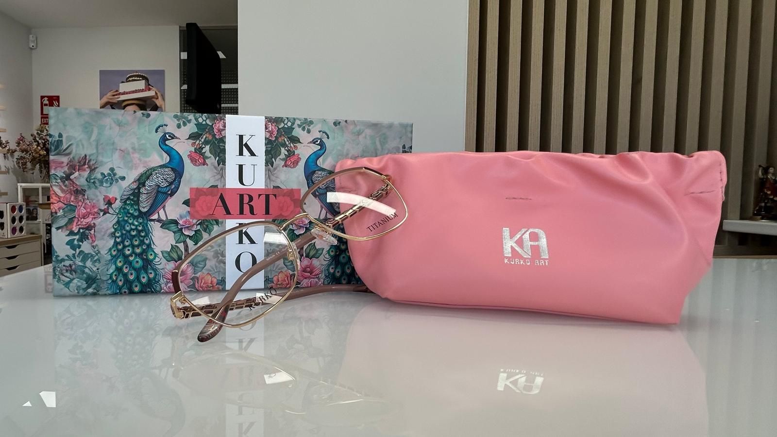Neceser rosa de KH junto a dos cajas de regalo con motivos florales sobre una mesa blanca