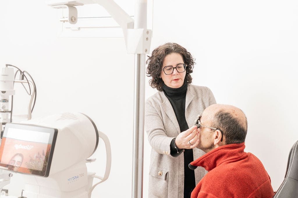 Dentista examinando a un paciente sentado en una clínica dental luminosa