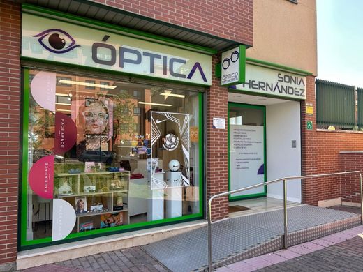 Fachada de Óptica and Sonia Fernández, con escaparates enmarcados en verde y una acera delante.